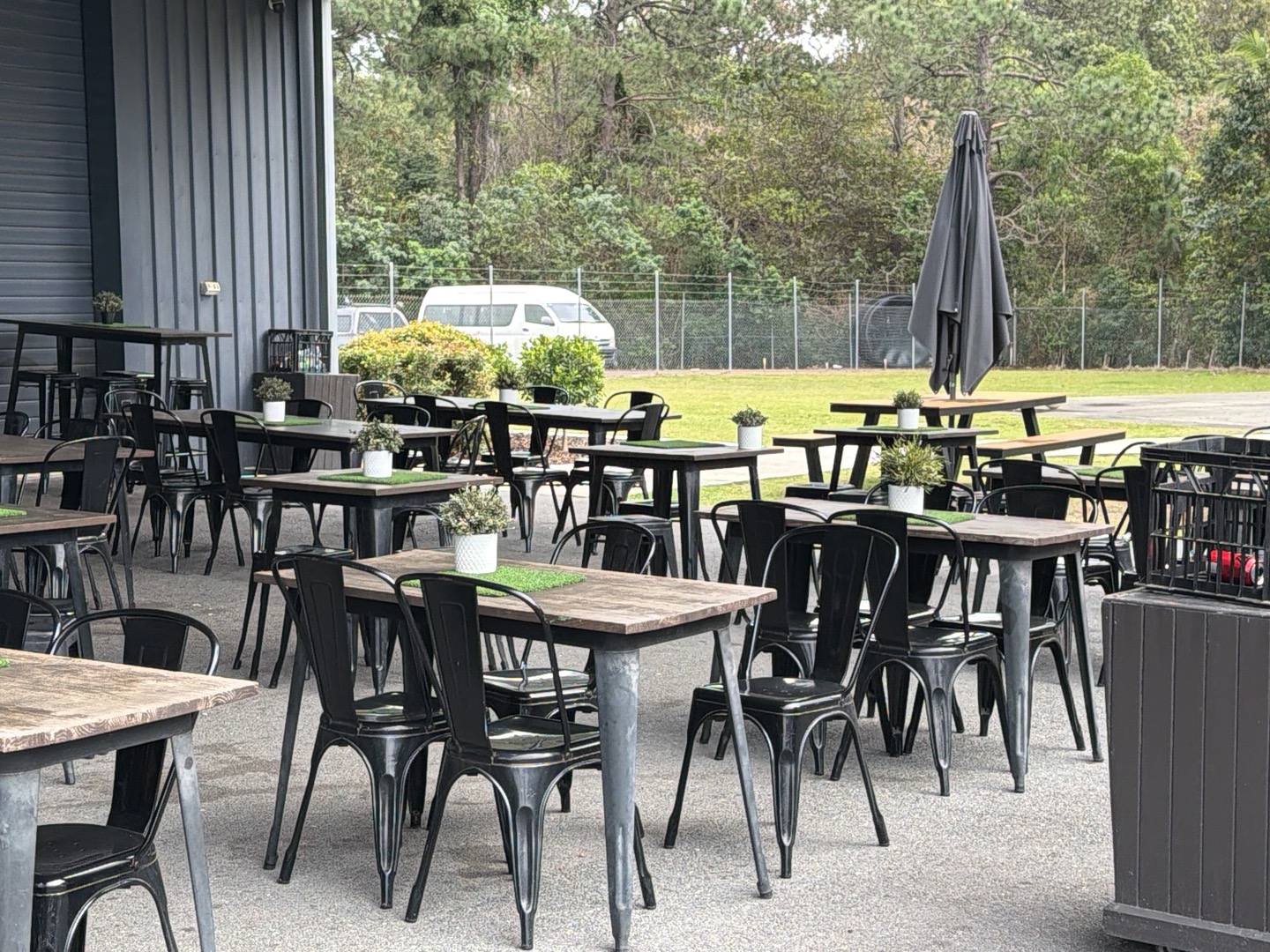 Outdoor tables, chairs and an umbrella set out on the lawn area