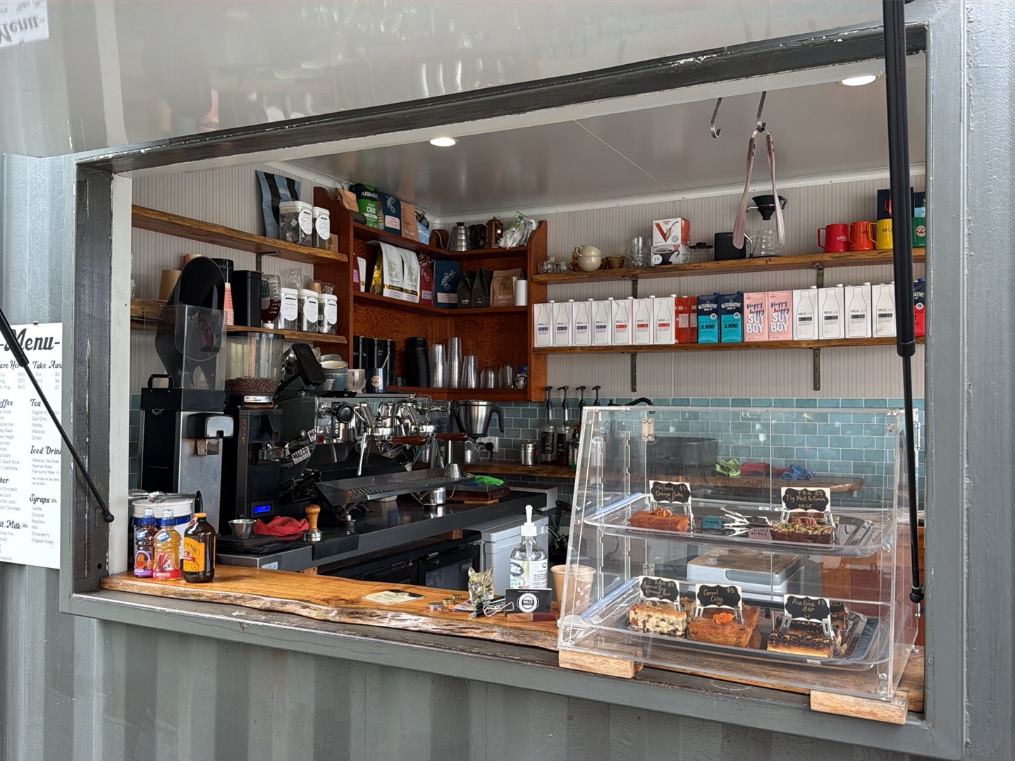 The counter inside, with tea and coffee stock on the shelves and a pastry case